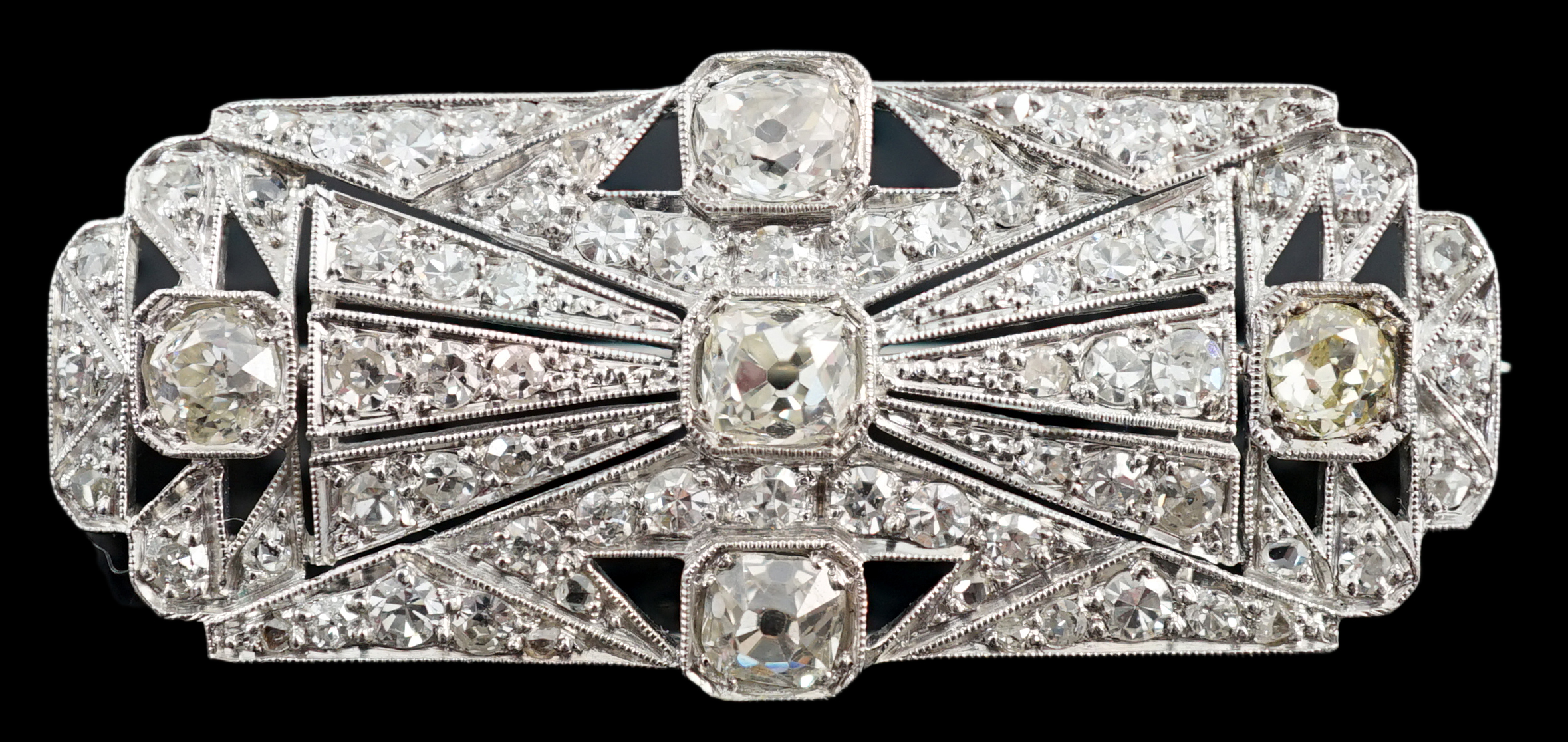 An Art Deco pierced platinum and millegrain set diamond cluster shaped rectangular brooch